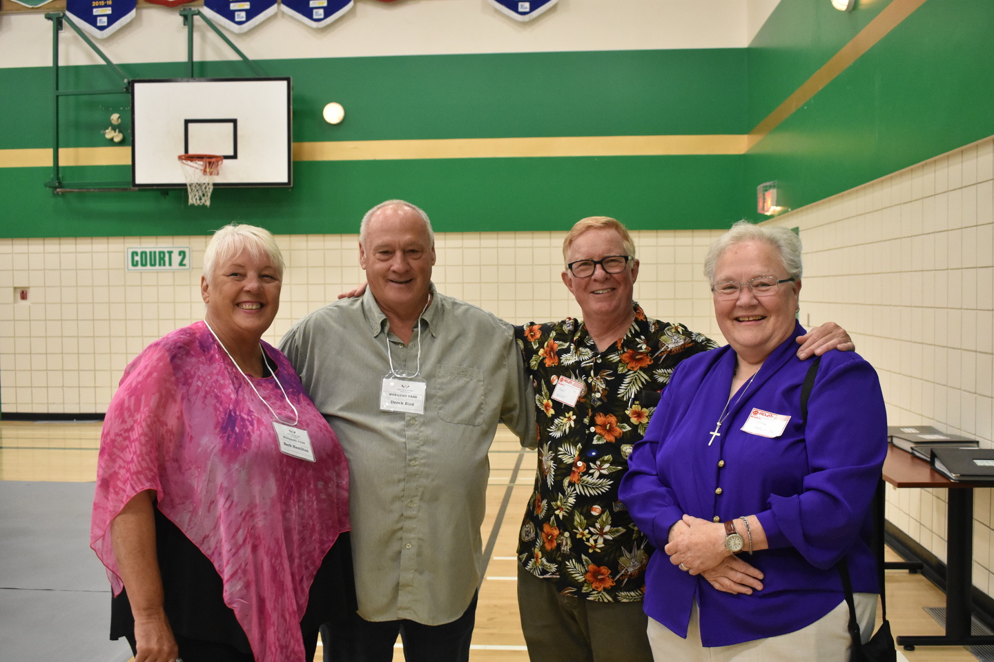 staff together and smiling for the picture in an event on the basketball court