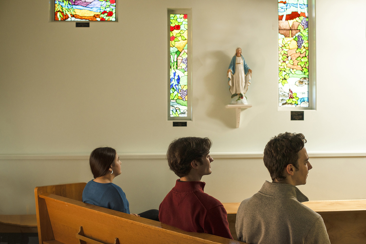 three people seated inside a church