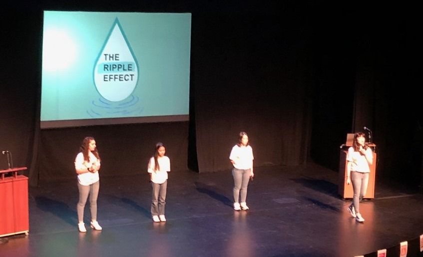 students giving a presentation in an auditorium