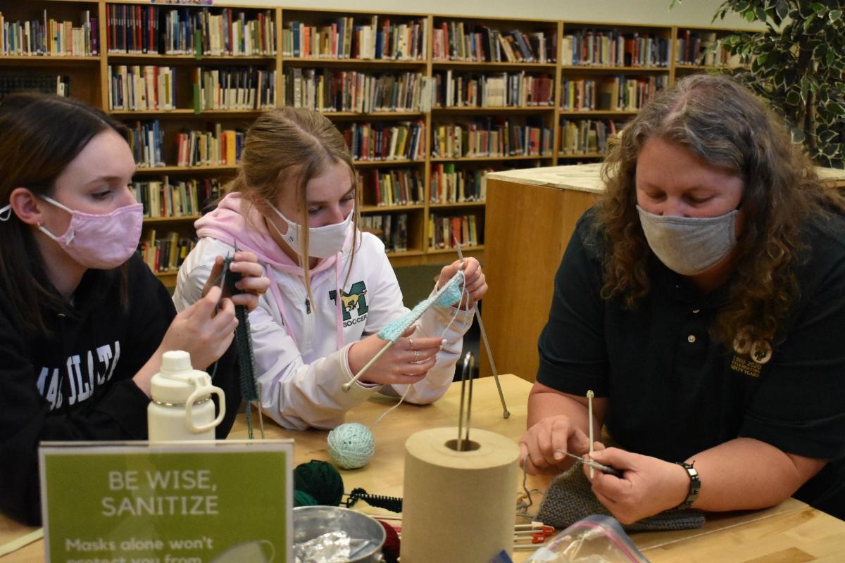 a teacher and two students doing craft activities