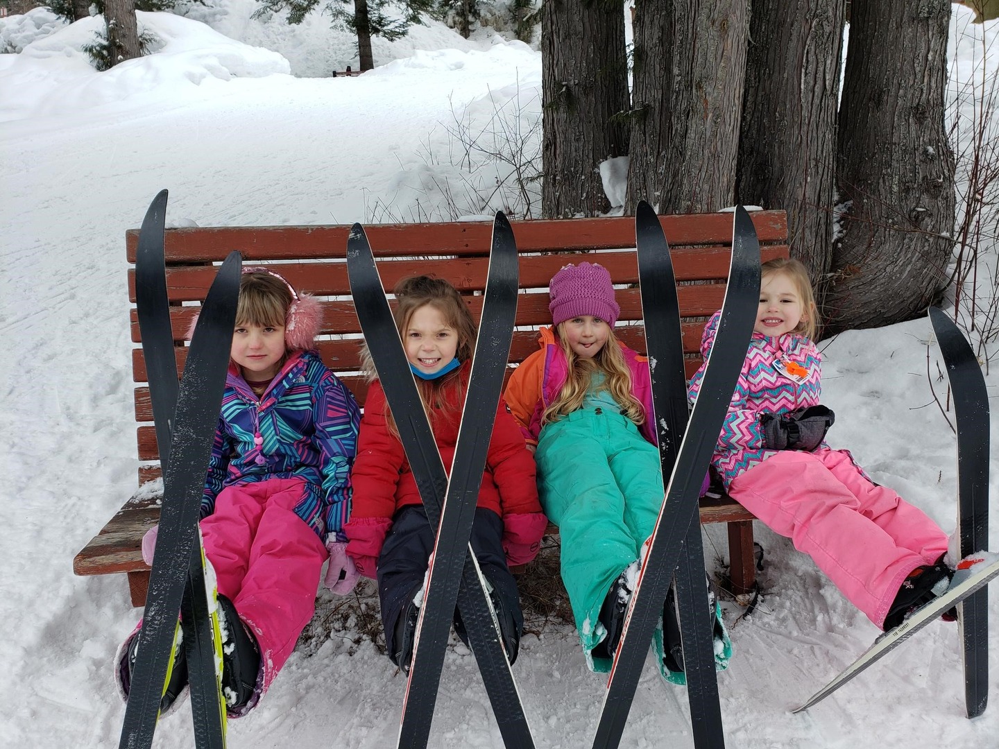 students with their skiing gear seating on a bench