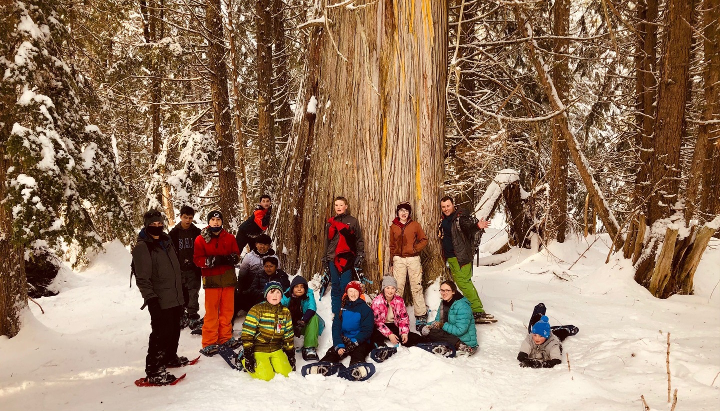 students after skiing in front of a big tree