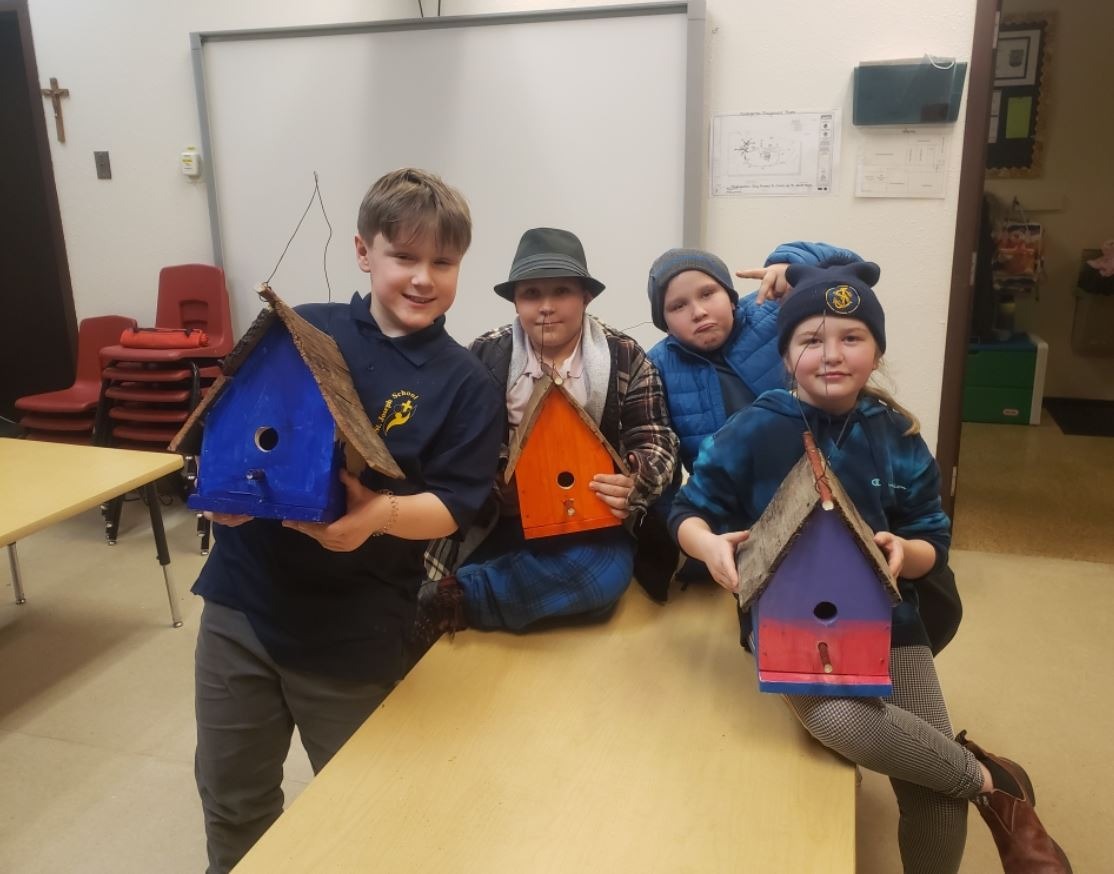students with some wood bird houses crafted by them