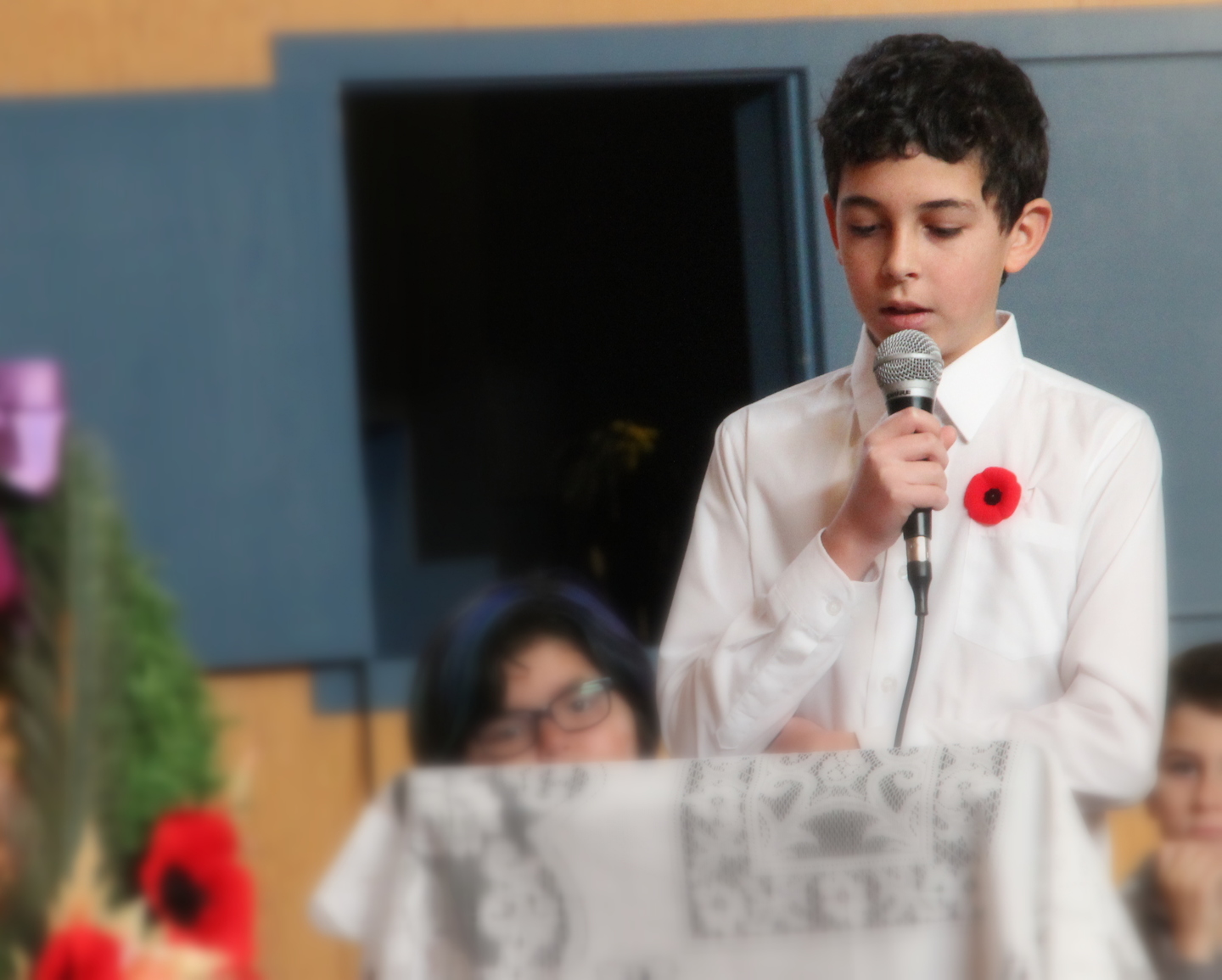 Student dress in white speaking on the microphone 