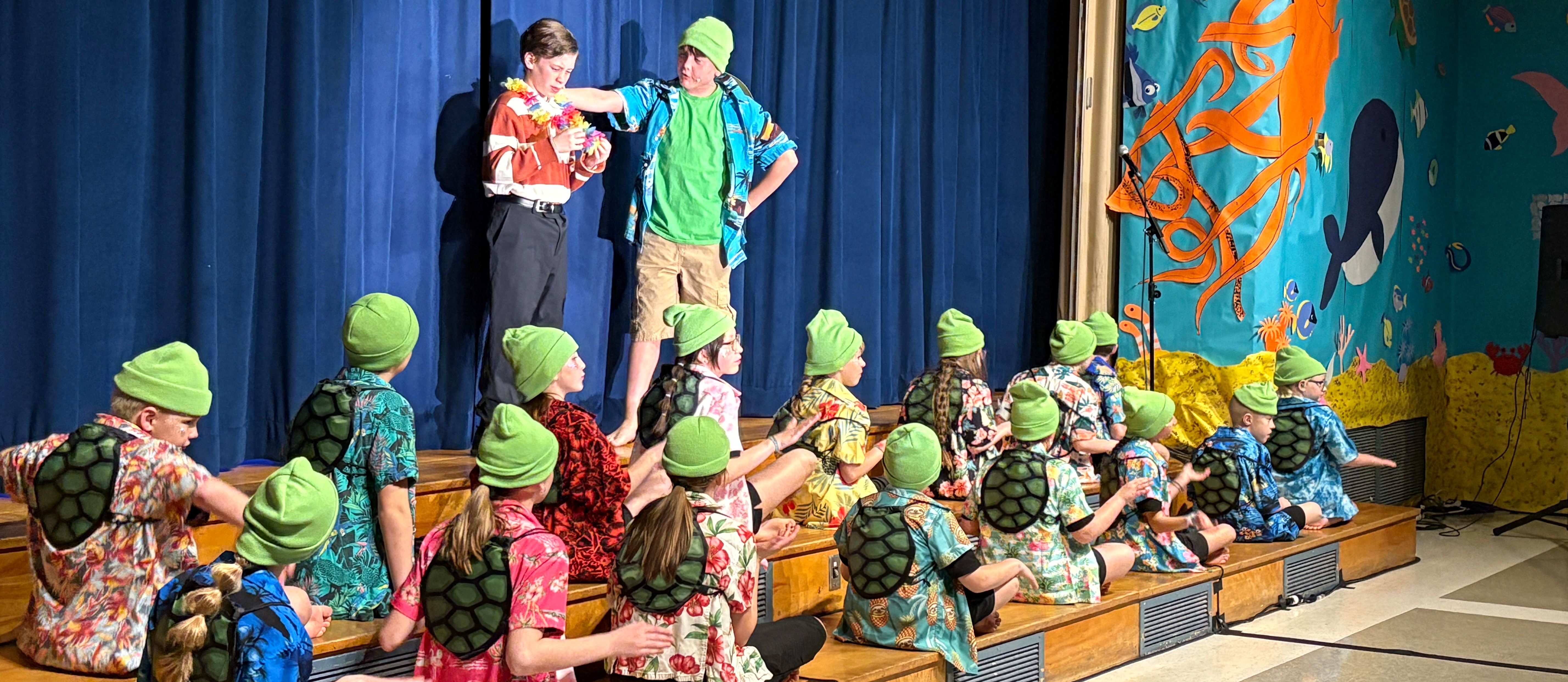 Students on a stage, most of them dressed as turtles, for the Finding Nemo Jr. play.