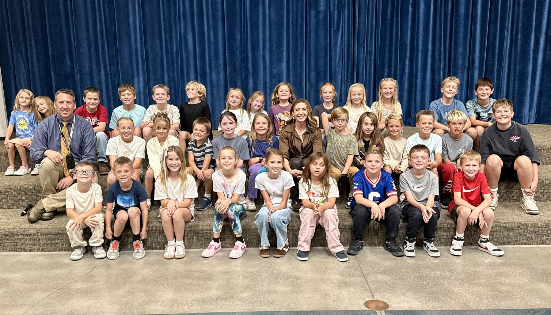Students sitting on the stairs with principal campbell for a party