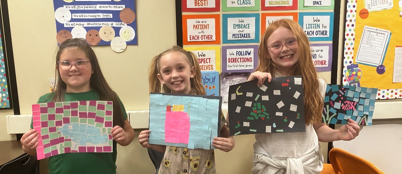 students posing with artwork