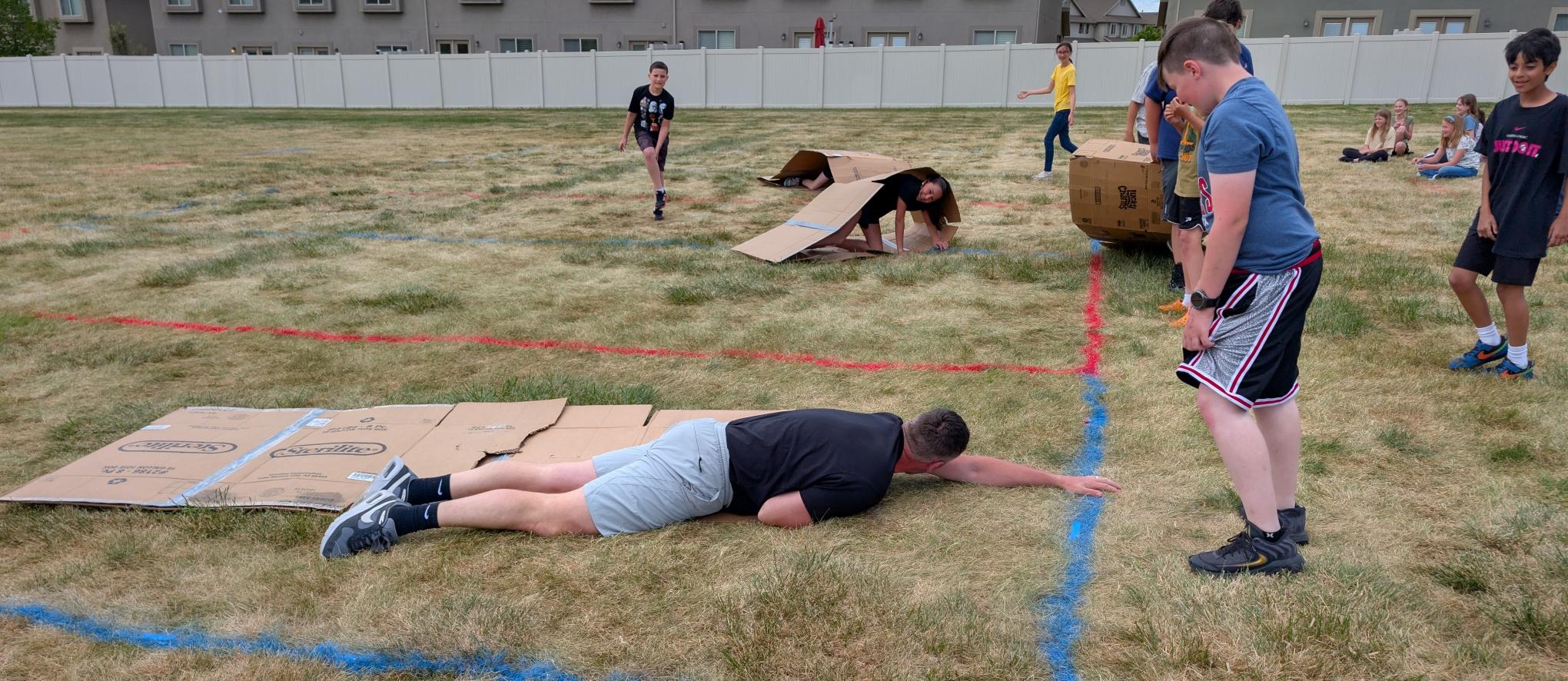 Mr. Nash and students at field day doing the hamster wheel with cardboard.