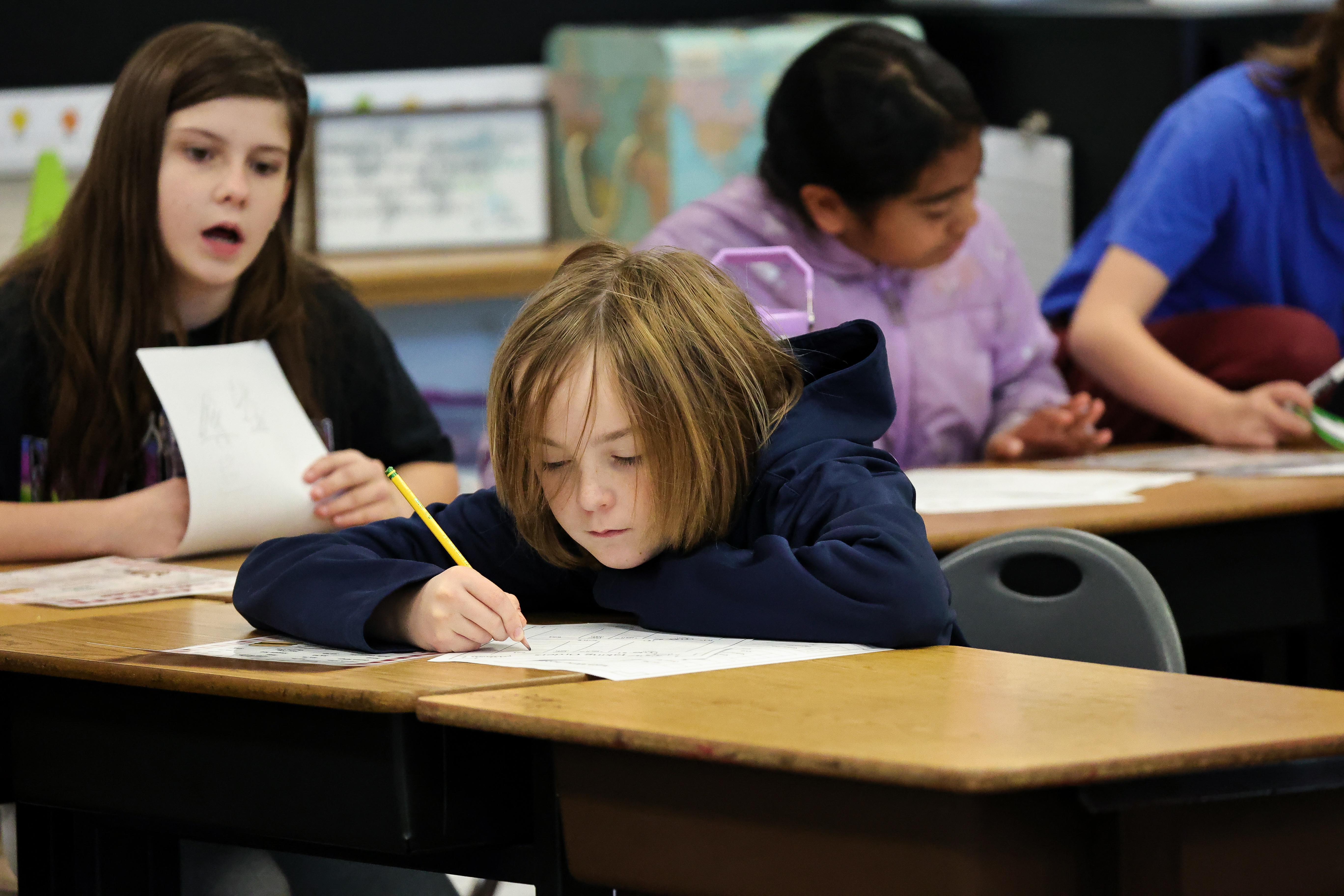 Student writing on paper