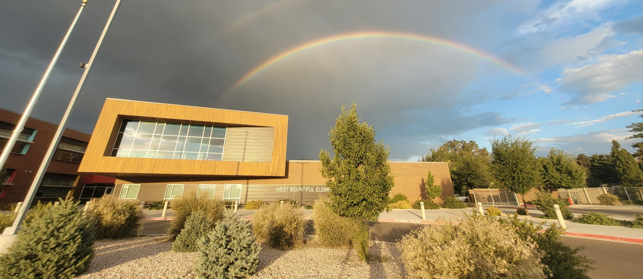 Exterior of West Bountiful Elementary with a rainbow across the sky. 