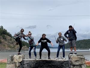 A picture of a group of people posing by a rock fence