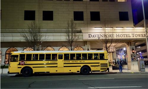 School bus parked infront of Devenport Hotel Tower