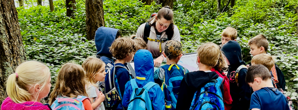 Teacher leading students on outside excursion.