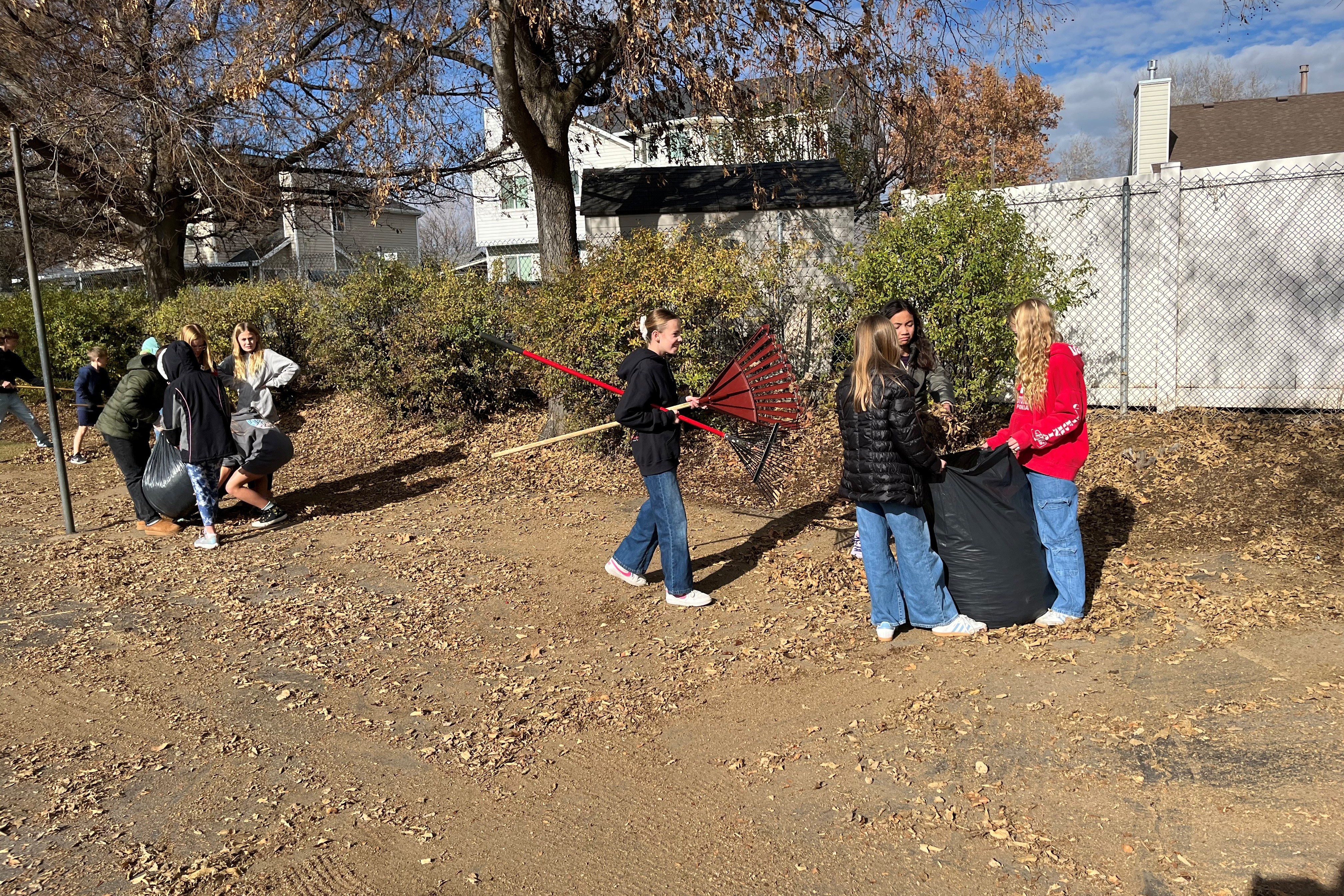 Kids raking leaves outside