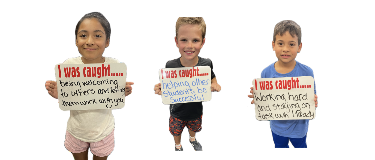 Three students holding signs that say:  I was caught...being welcoming to others and letting them work with you.  I was caught...helping other students be successful.  I was caught...working hard and staying on task with iReady.  