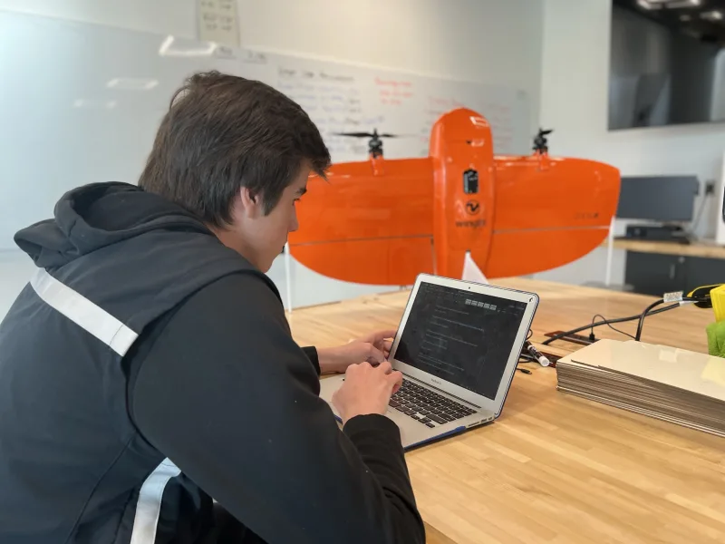 student infront of a laptom and a little orange submarine