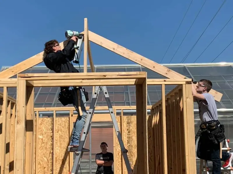 3 students building a shed