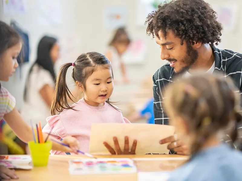 Teacher at class room teaching students