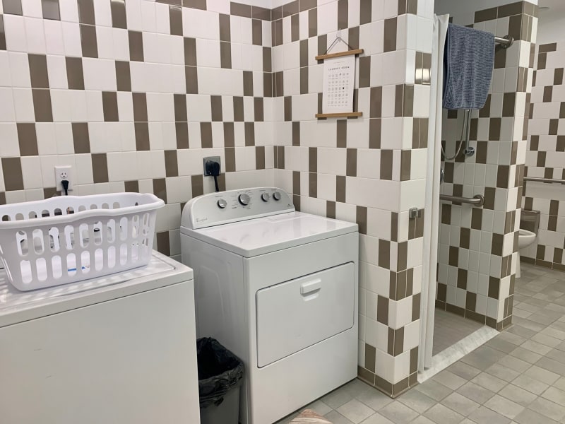 A clean and well-organized bathroom with a washing machine.