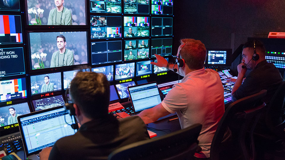 two individuals working at a media broadcasting booth