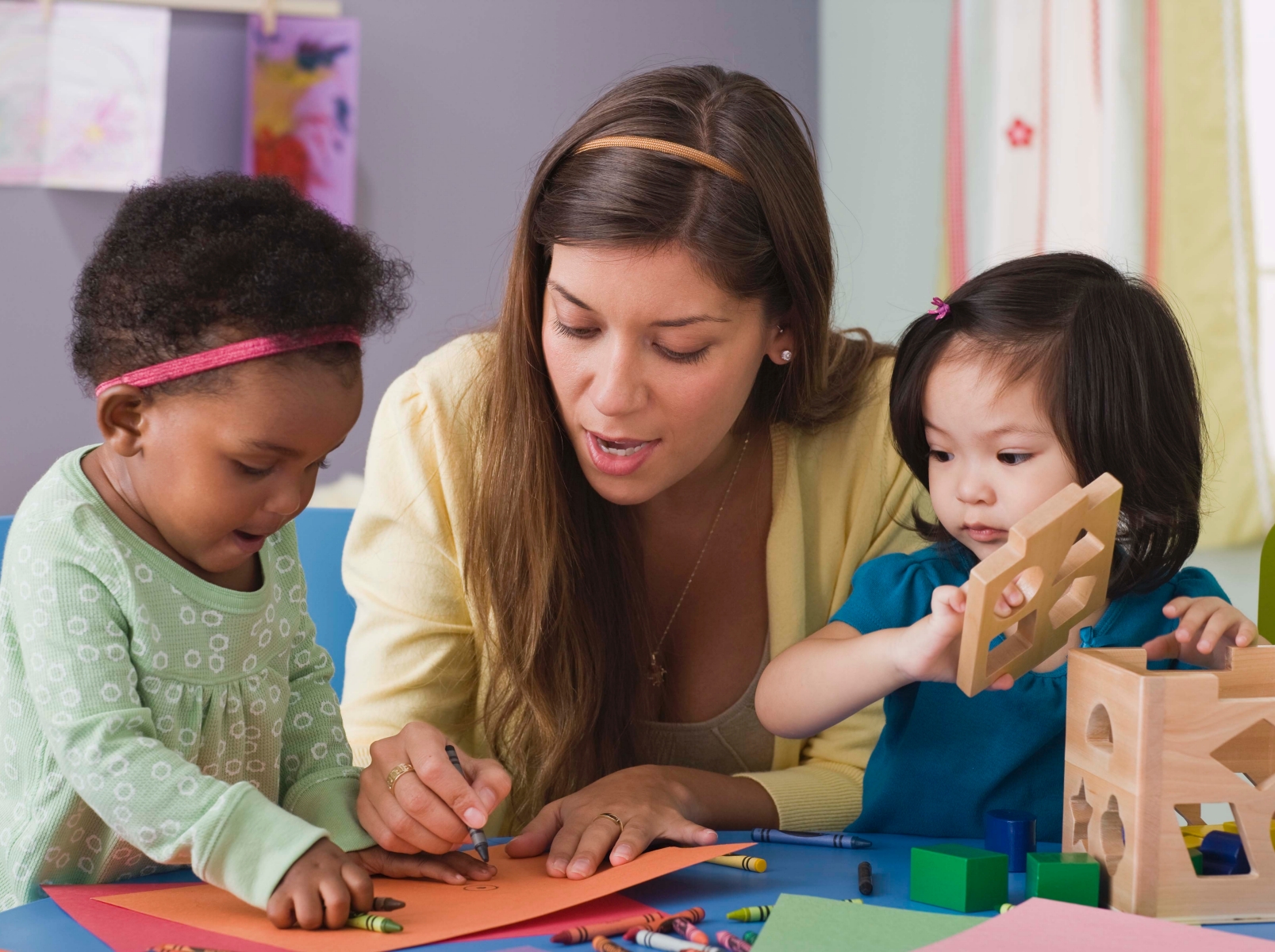 woman teaching two toddlers