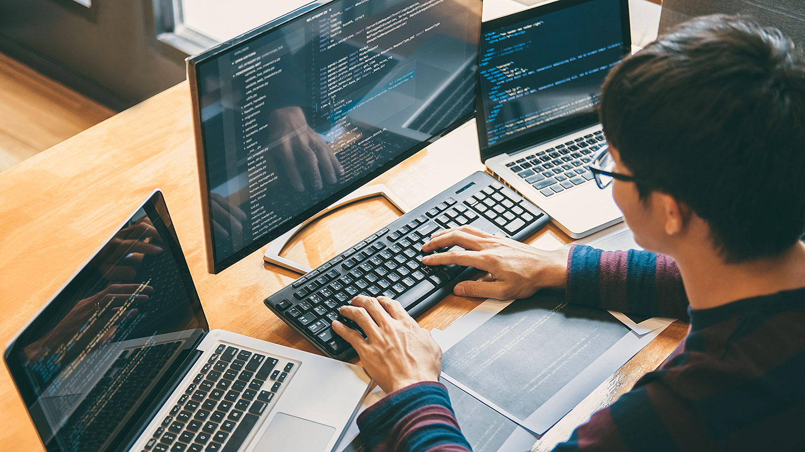 programmer typing at computer keyboard