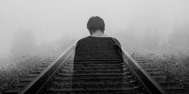 man walking down the train tracks