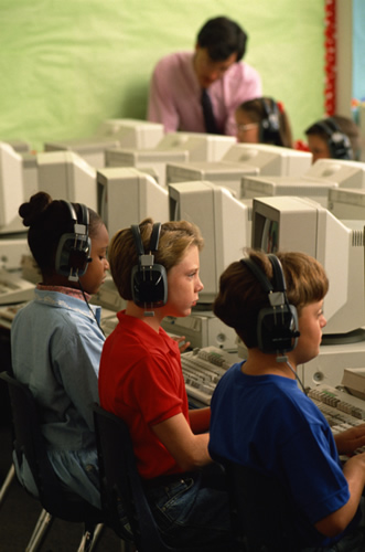 Children sitting at computers, engaged in learning activities.