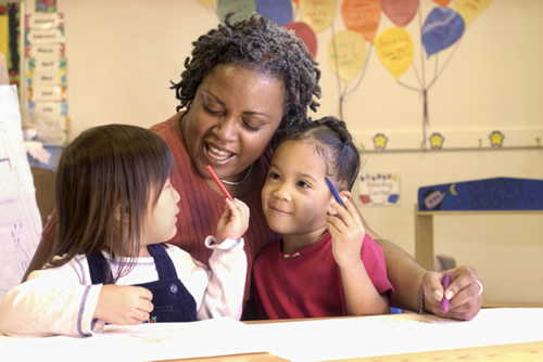 A woman and two children sitting at a table, engaged in conversation and enjoying a meal together.