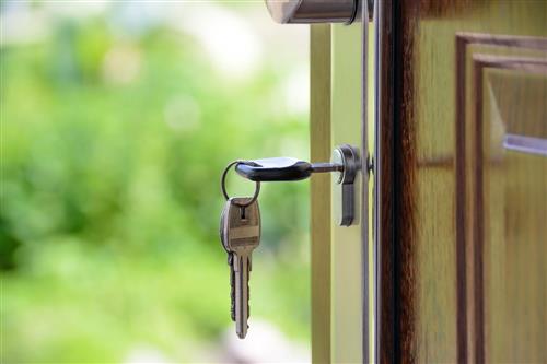 Key hanging from door handle, symbolizing access or security.
