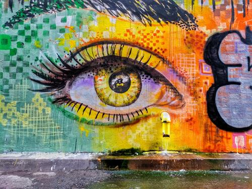 Colorful graffiti wall with a painted eye, vibrant street art adding a pop of color to the urban landscape.