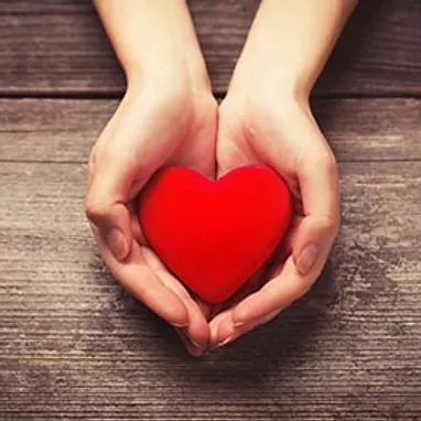 hands holding a red cartoon heart