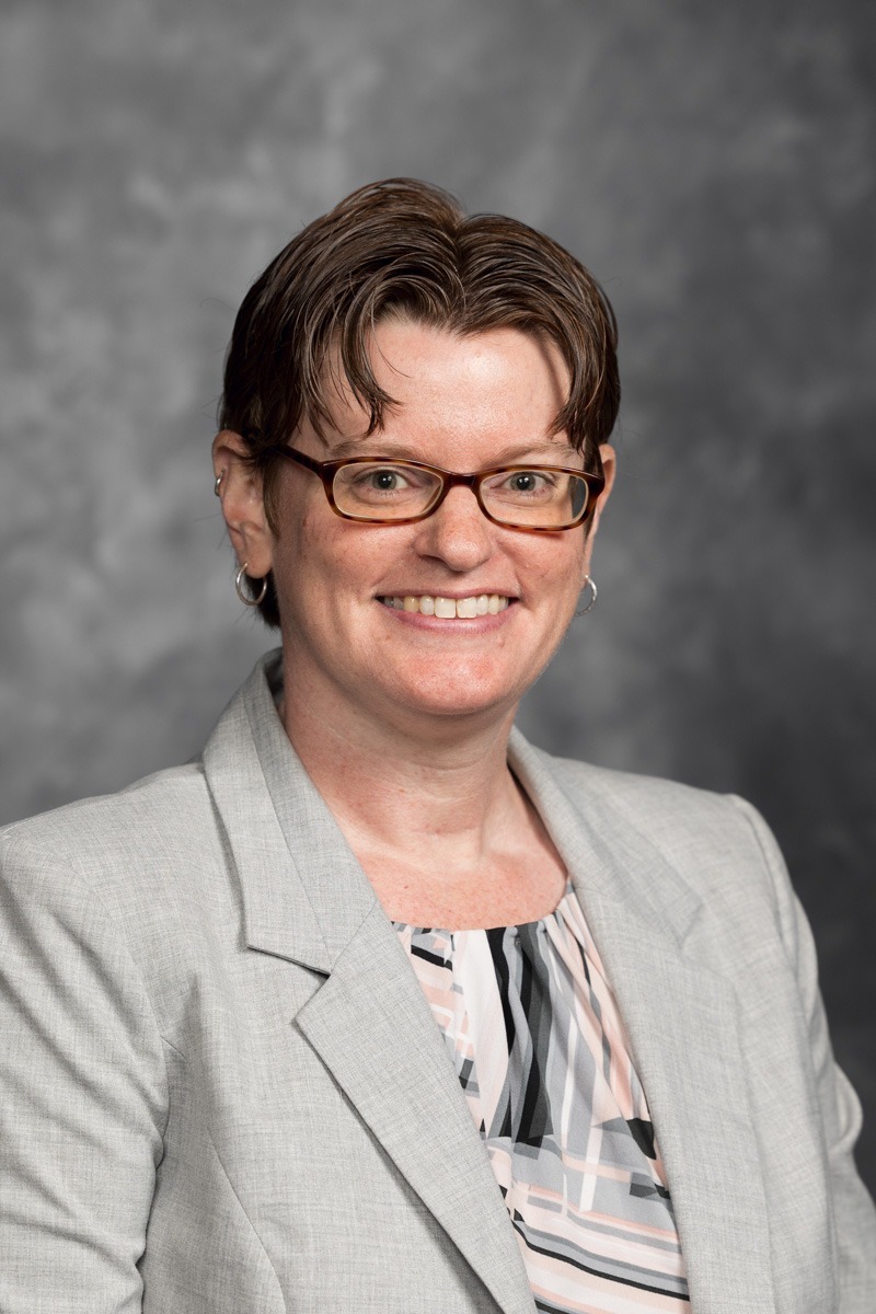 Picture of woman with short hair and a tan suit jacket