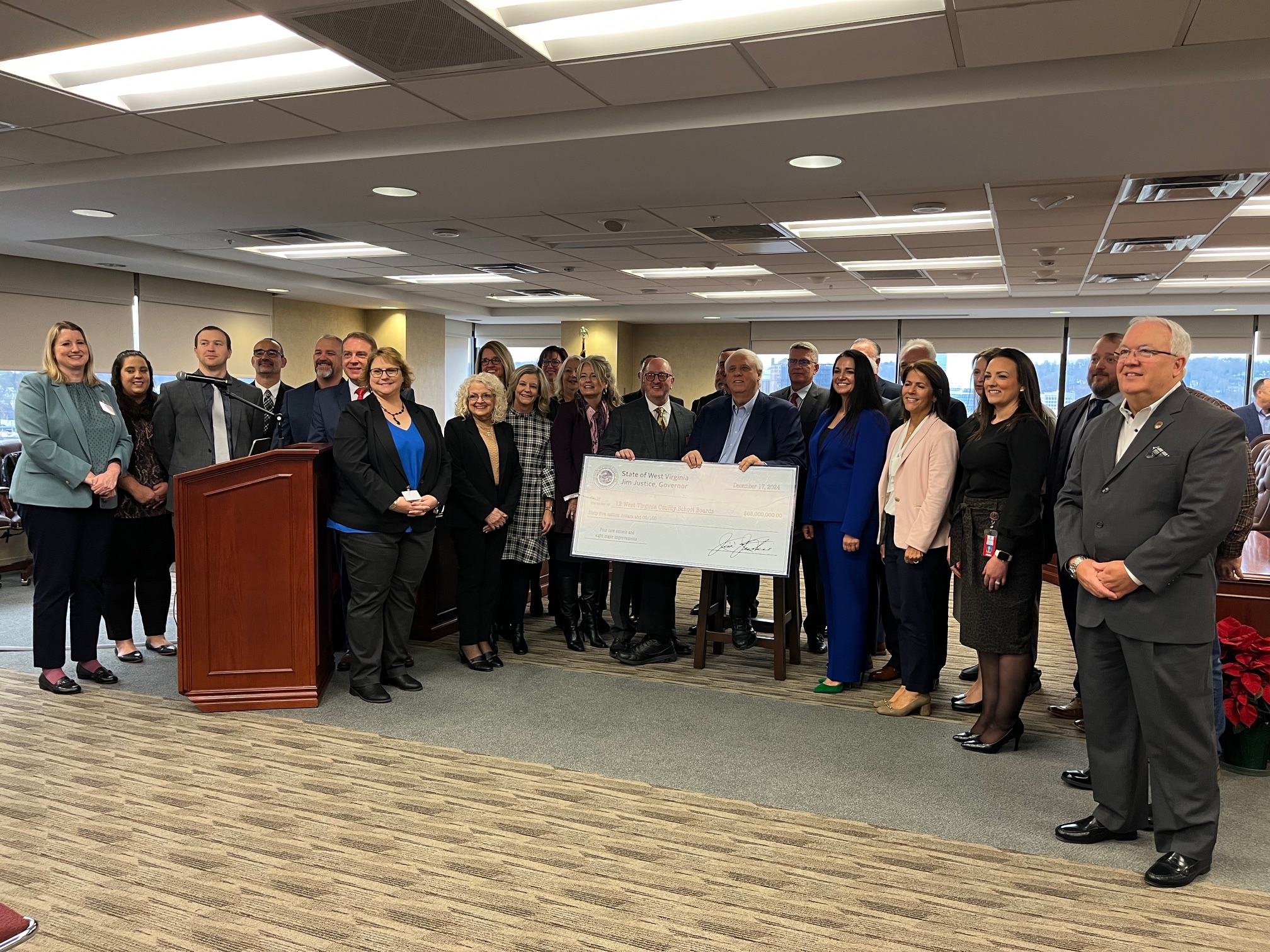 School Building Authority Members and Governor Justice holding large check