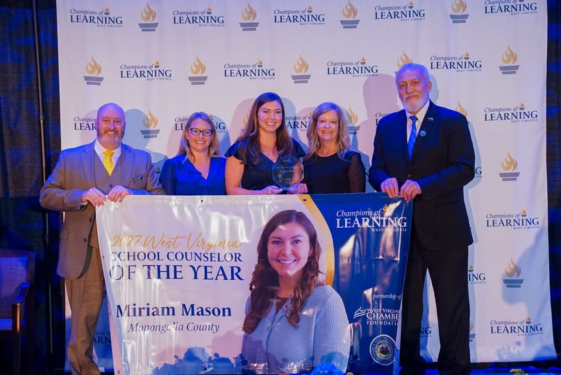 Dr. Campbell, state leadership and WV School Counselor of the Year, Miriam Mason standing holding poster of Miriam's honor