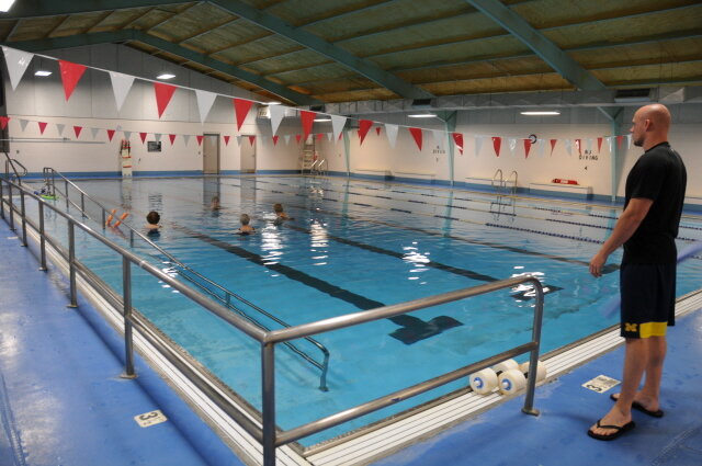 An indoor swimming pool, where a lifeguard is on duty.