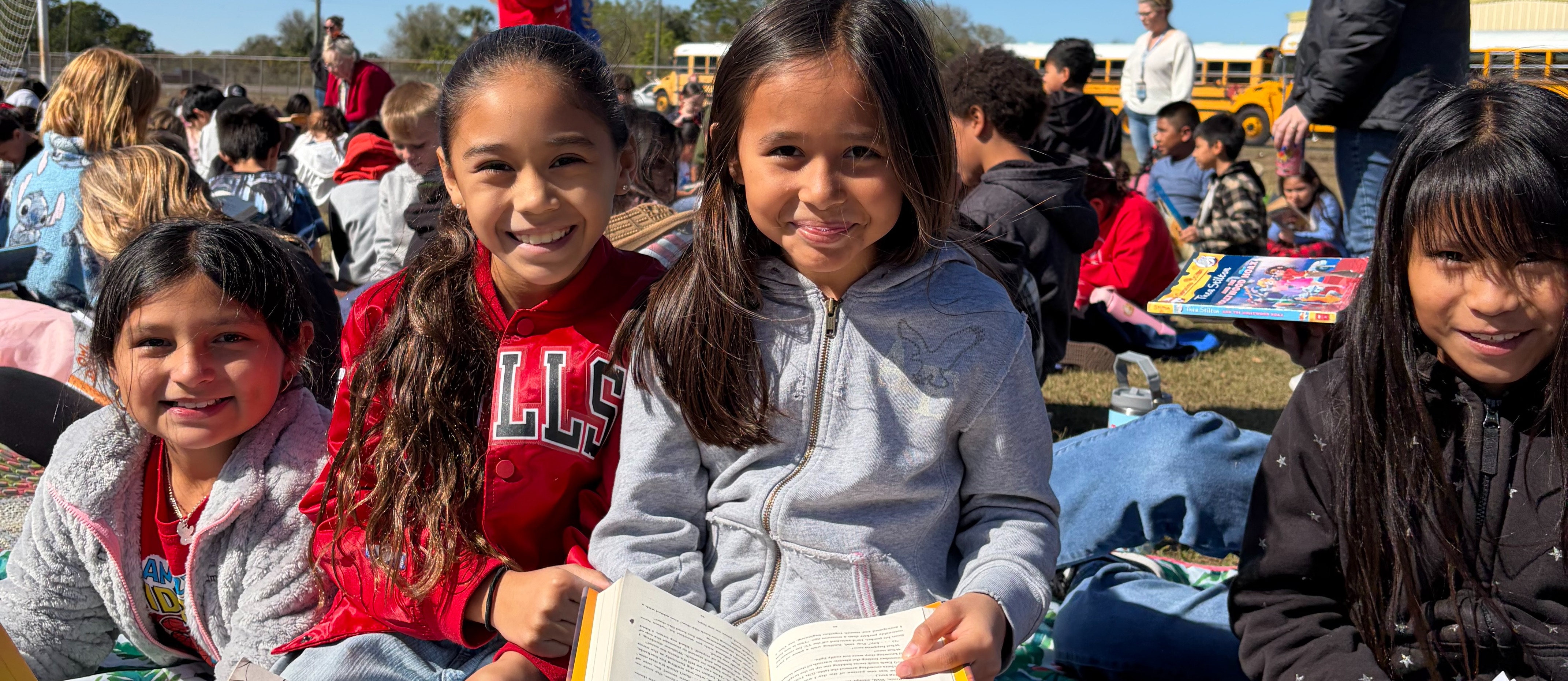 students rading a book outside