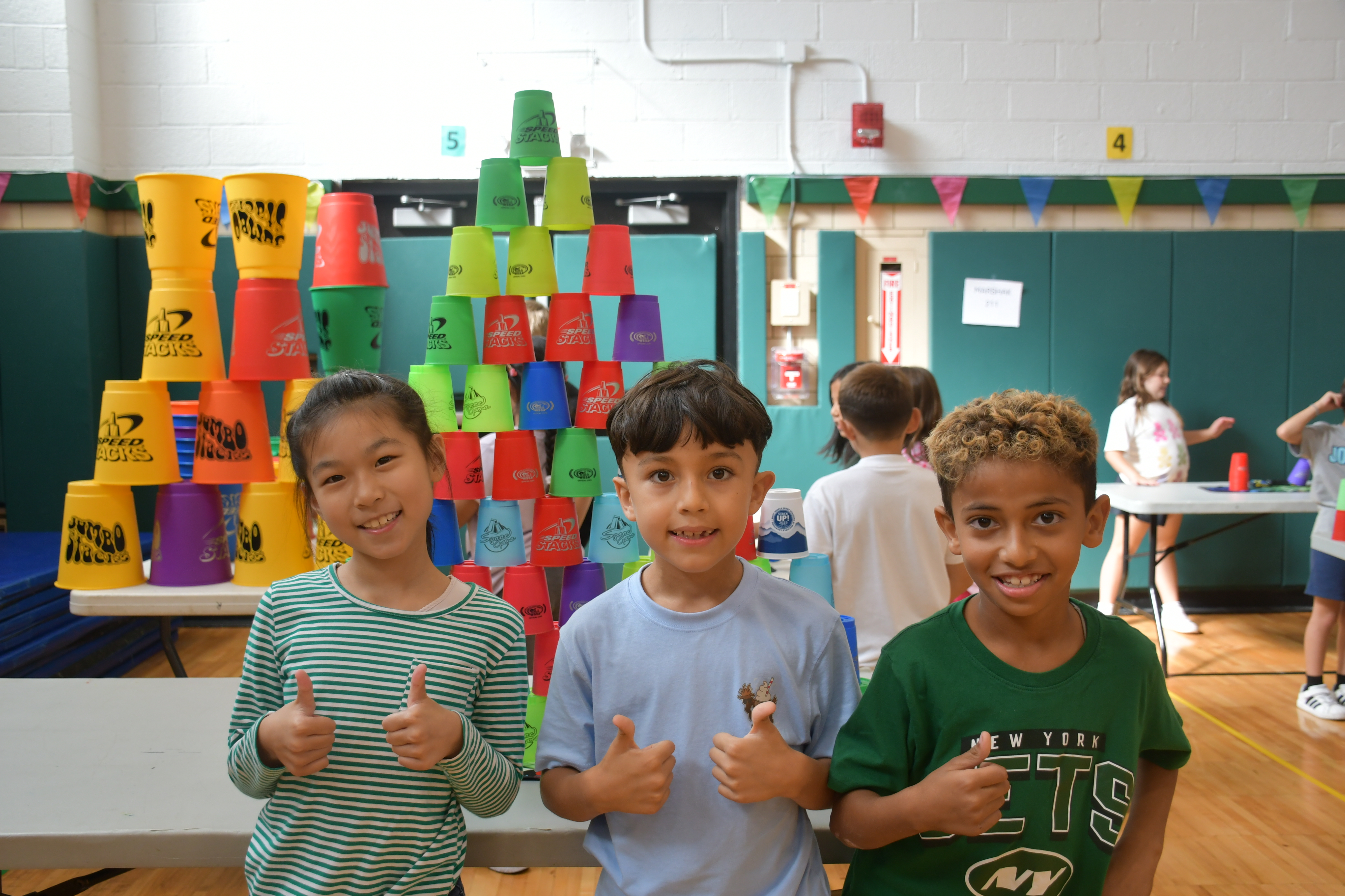 Students smiling in front of their projects.