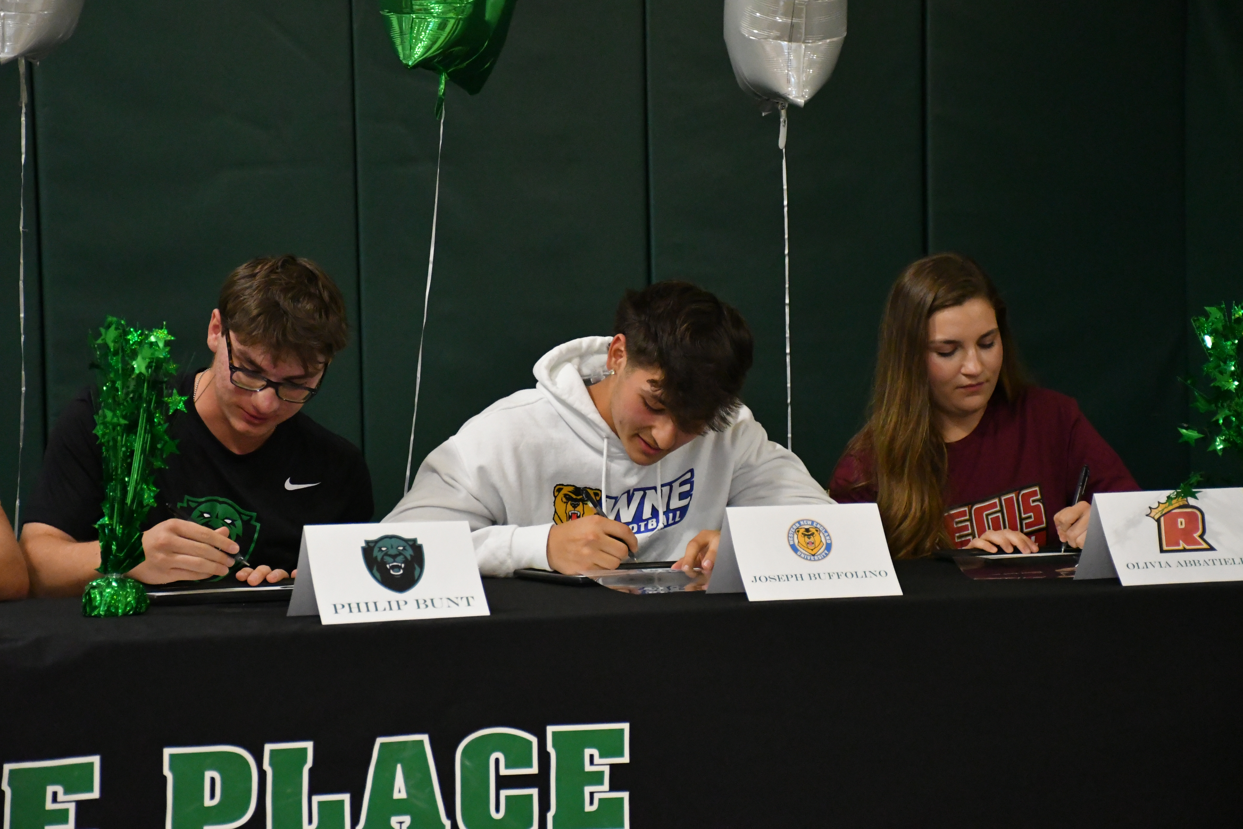 Students signing at table.