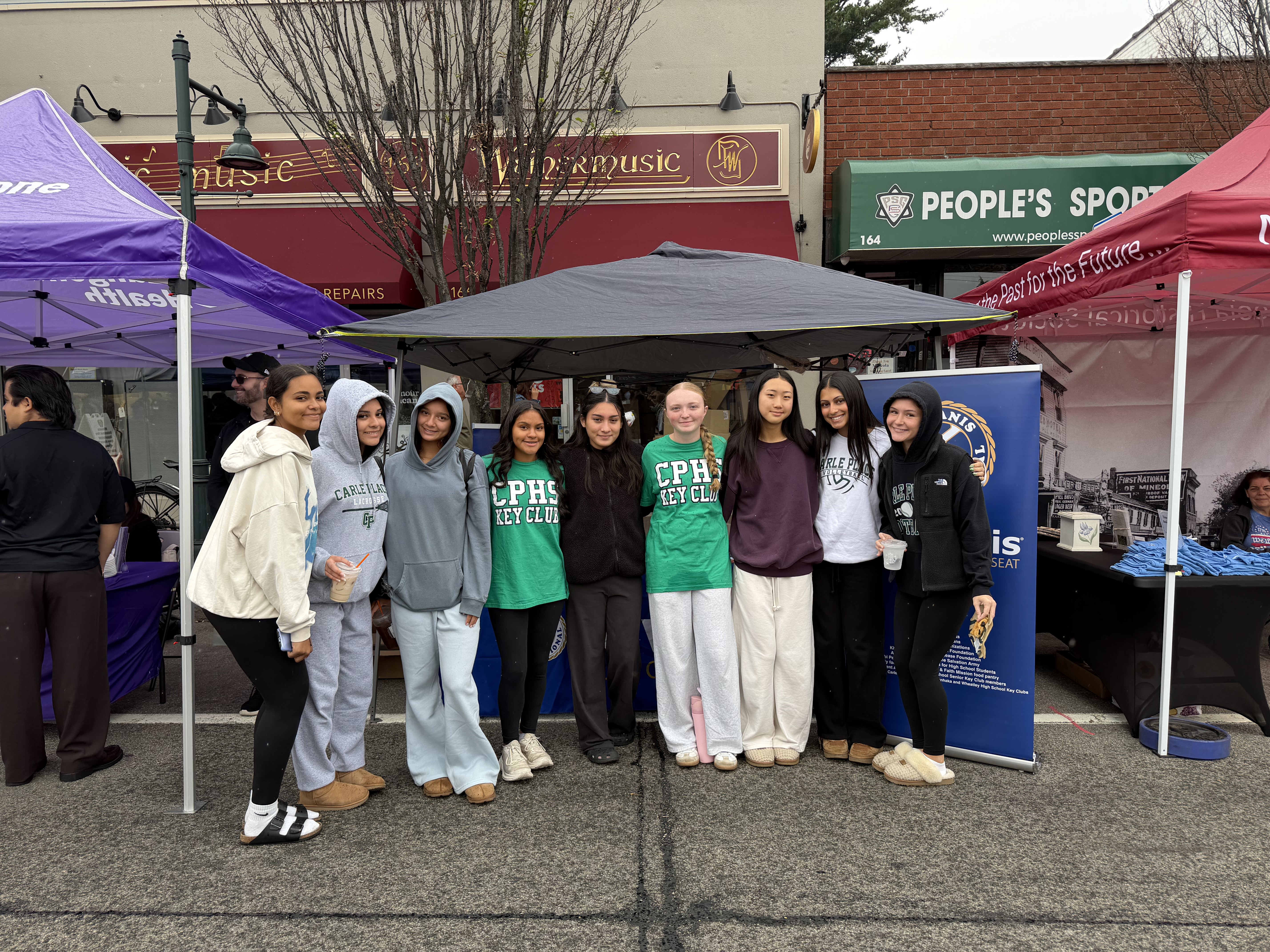 Students standing outside under tent.