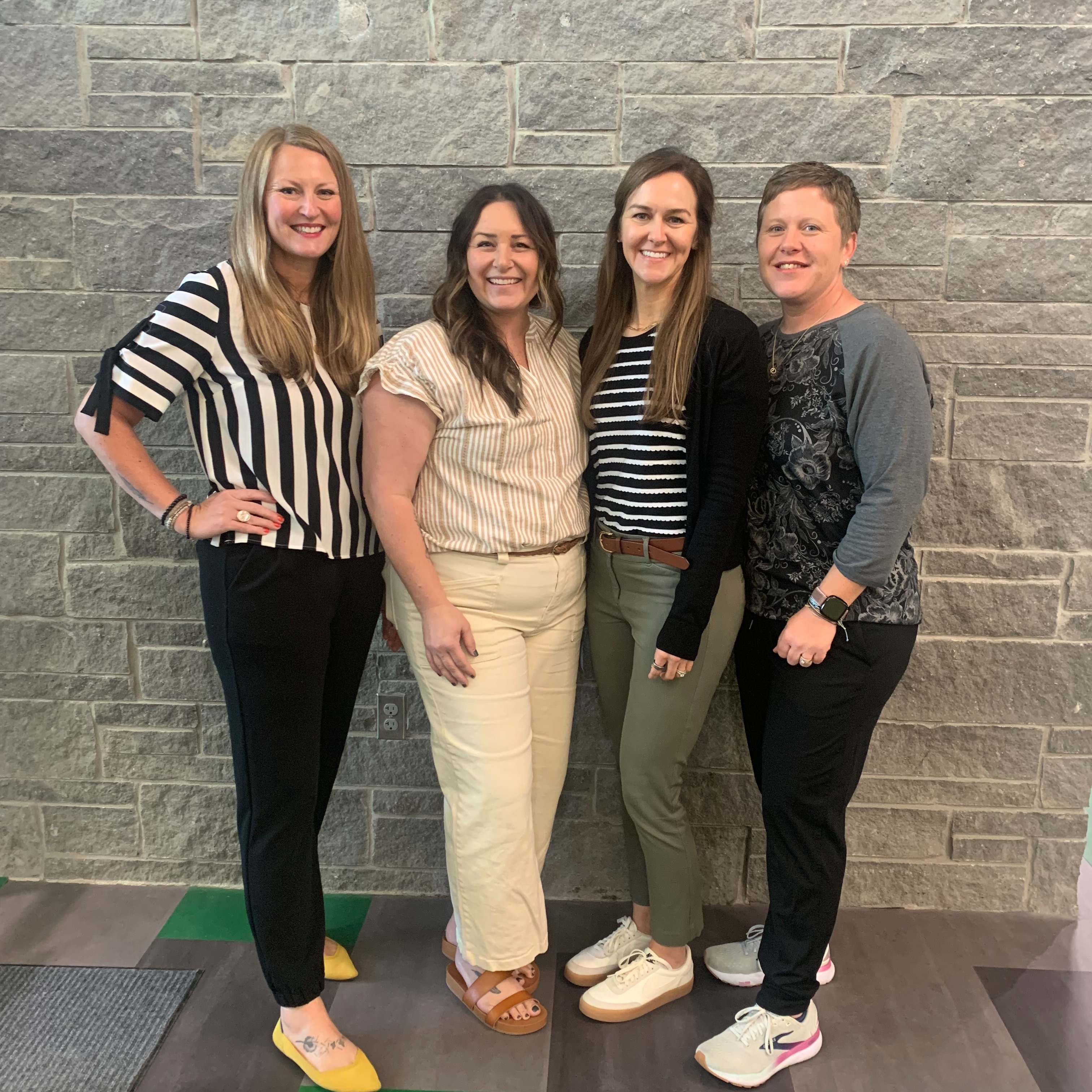 Four female office staff members posing for a picture