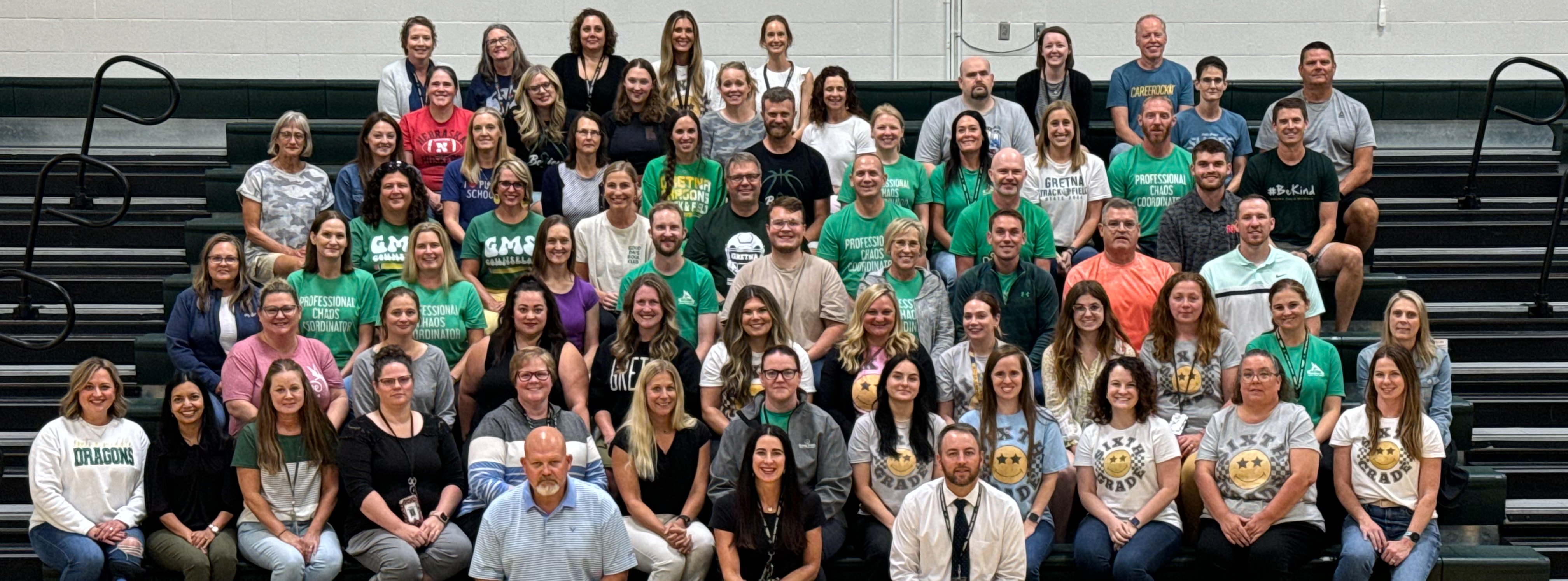 All staff of Gretna Middle School sitting in bleachers posing for camera.