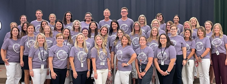 all staff of Palisades Elementary School standing in front of the state wearing their school gear.