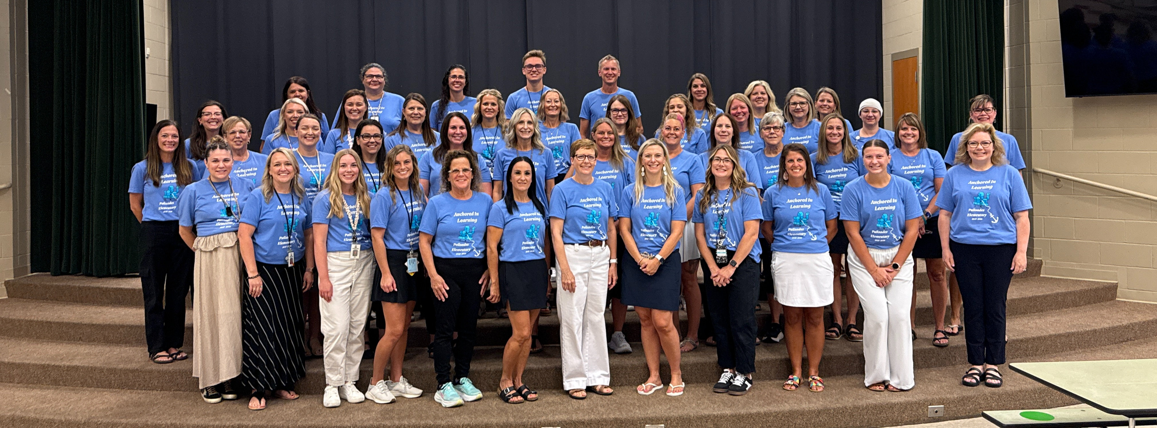 The PES staff pose for a group picture on the stage.