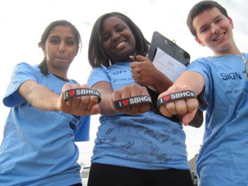 Students wearing the same shirt showing a similar band on their right hand