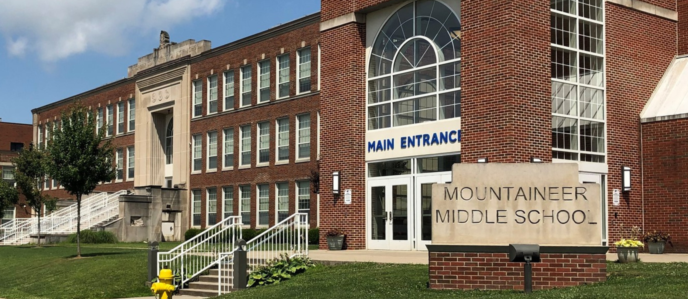 front of Mountaineer Middle School building with blue sky and green grass 