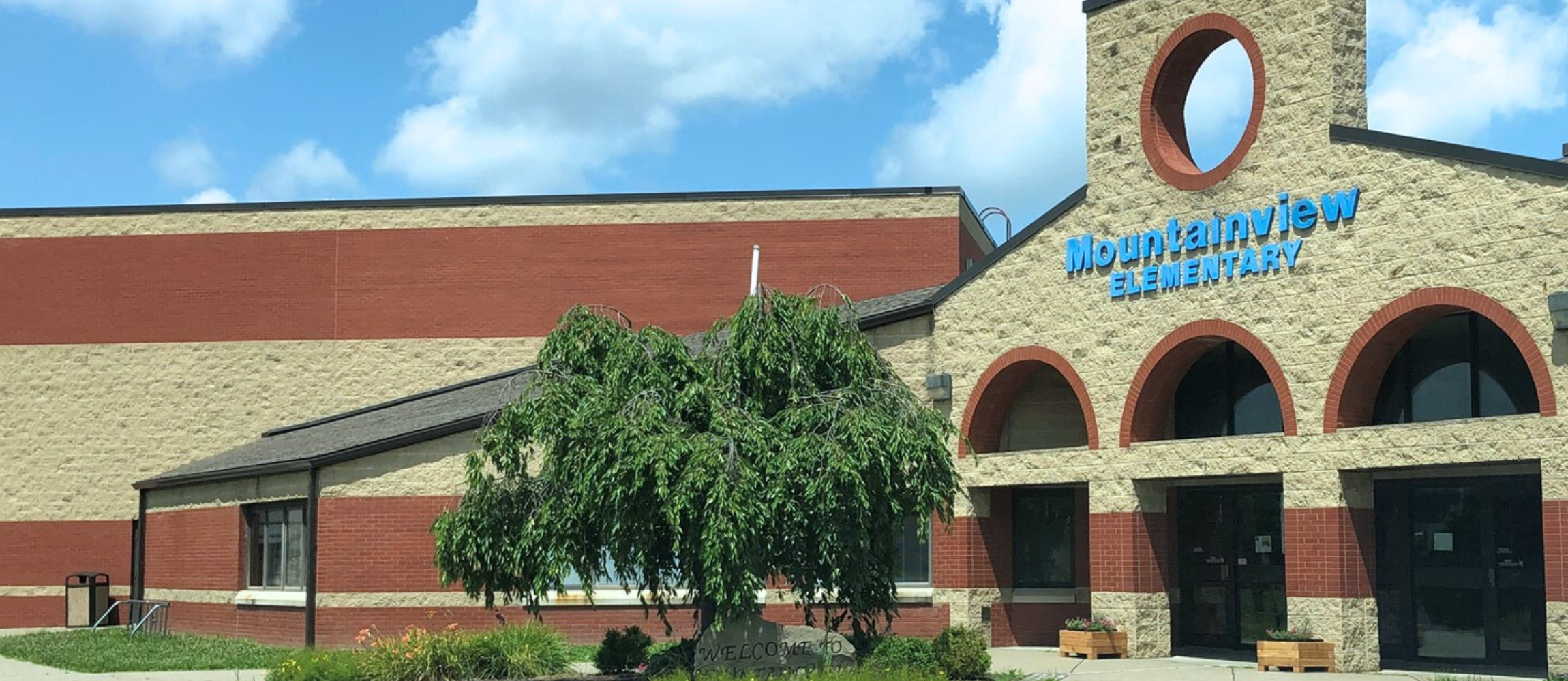 front of Mountainview Elementary with blue skies, green tree 