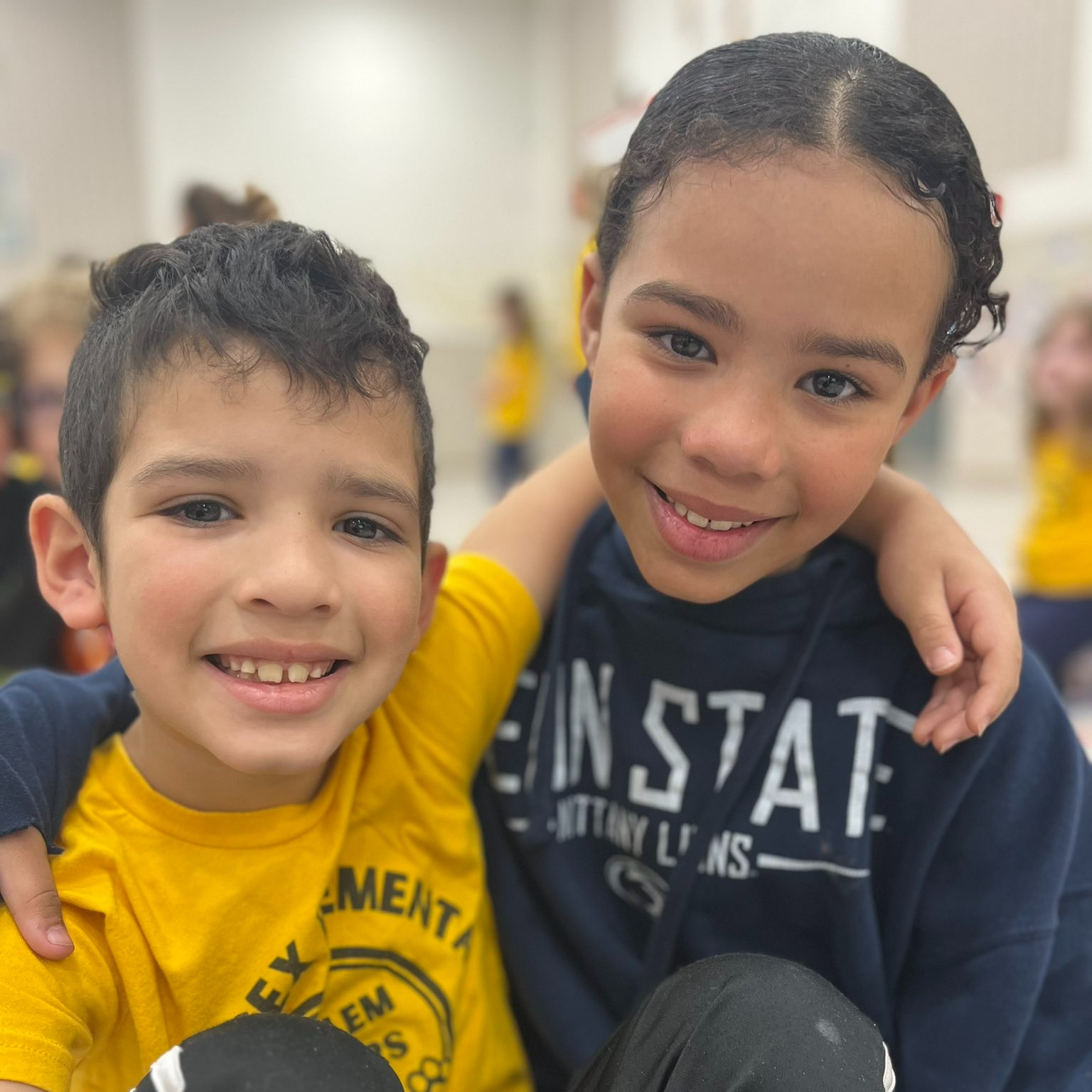 Young boy in yellow shirt and young girl in penn state sweatshirt.