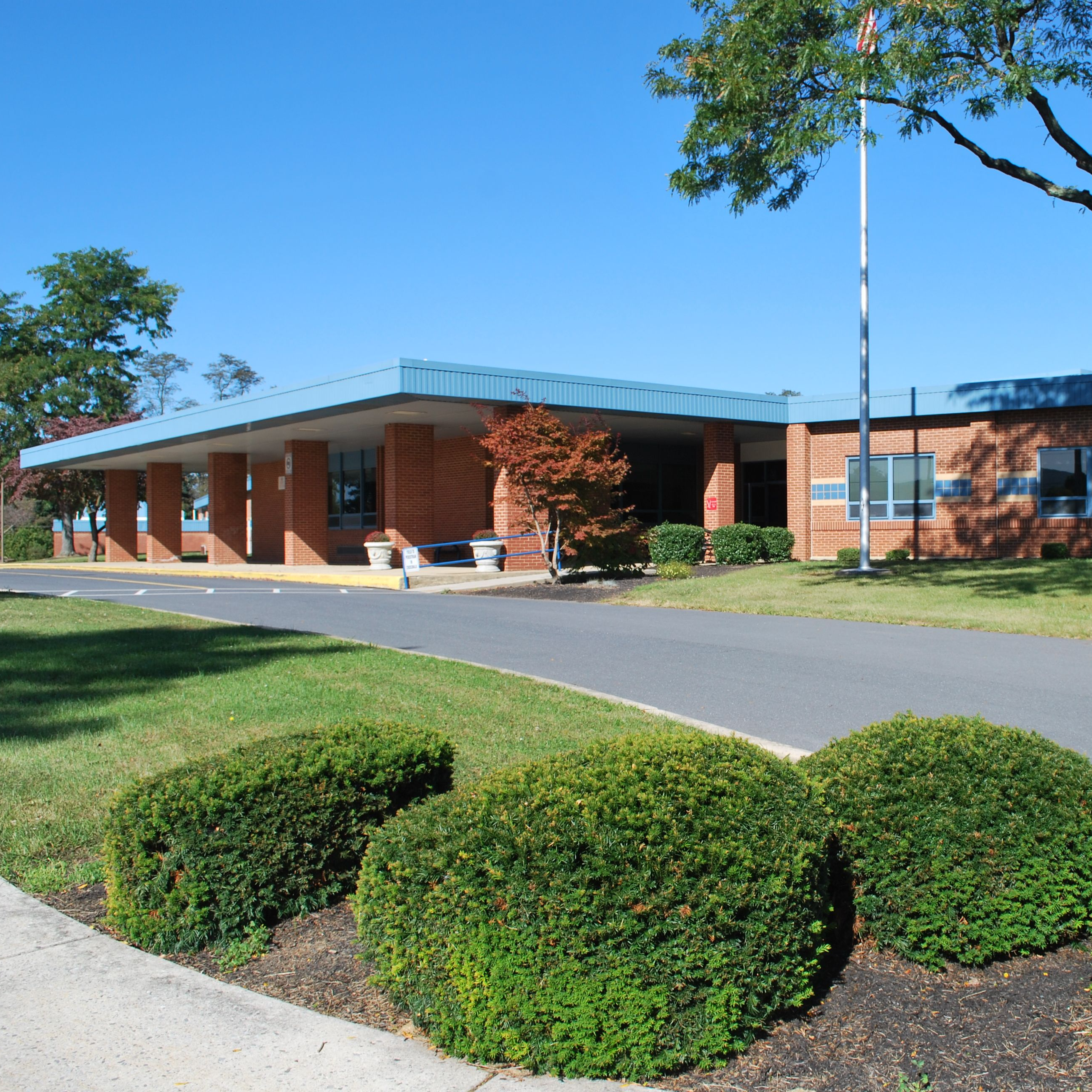 Picture of brick school with blue roof and blue skyline.