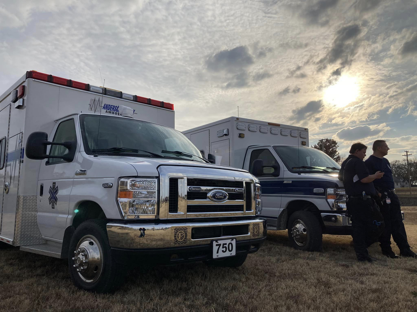 An ambulance car with men standing infront of it